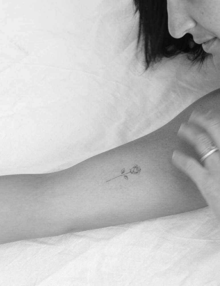Single needle rose tattoo located on the inner forearm.