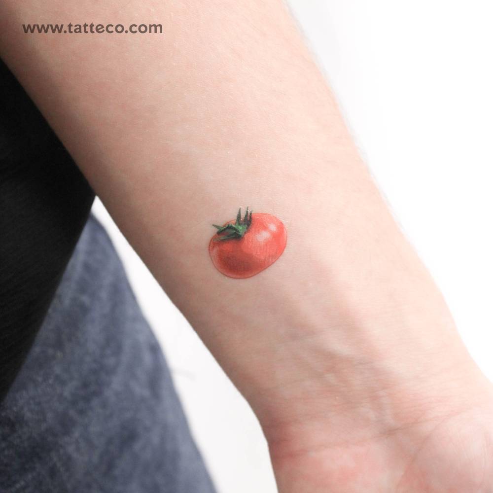 Micro-realistic style red tomato temporary tattoo located on the wrist.