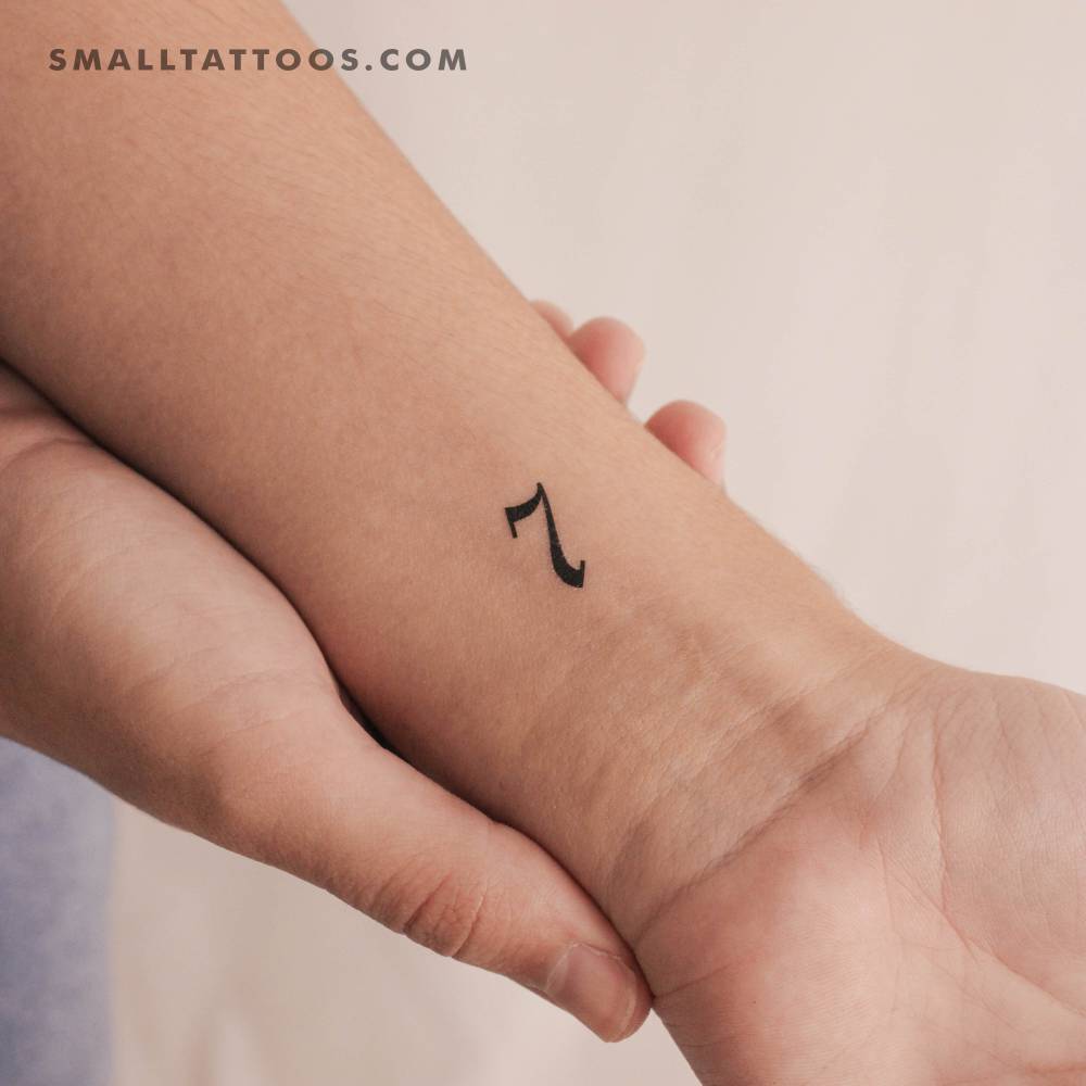 Old English number "7" temporary tattoo located on the wrist.
