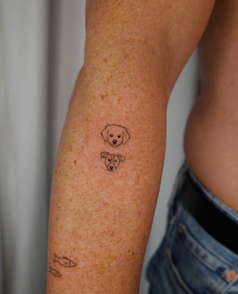 Dogs portrait tattooed on the forearm, done in minimalistic style.