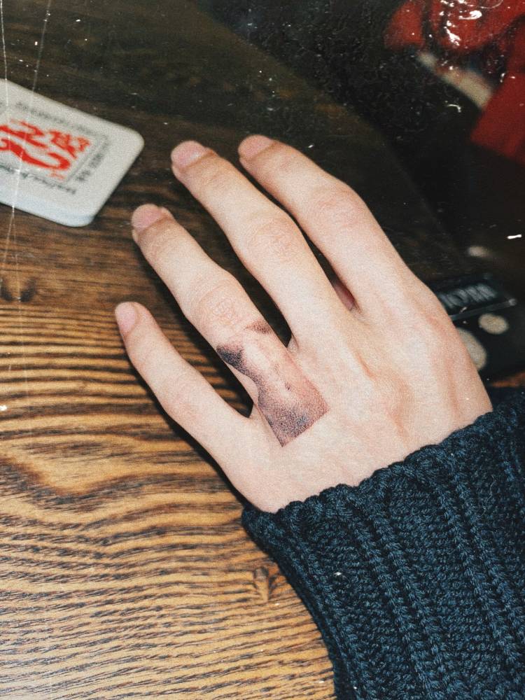 Nude female body tattooed on the finger in dotwork style.