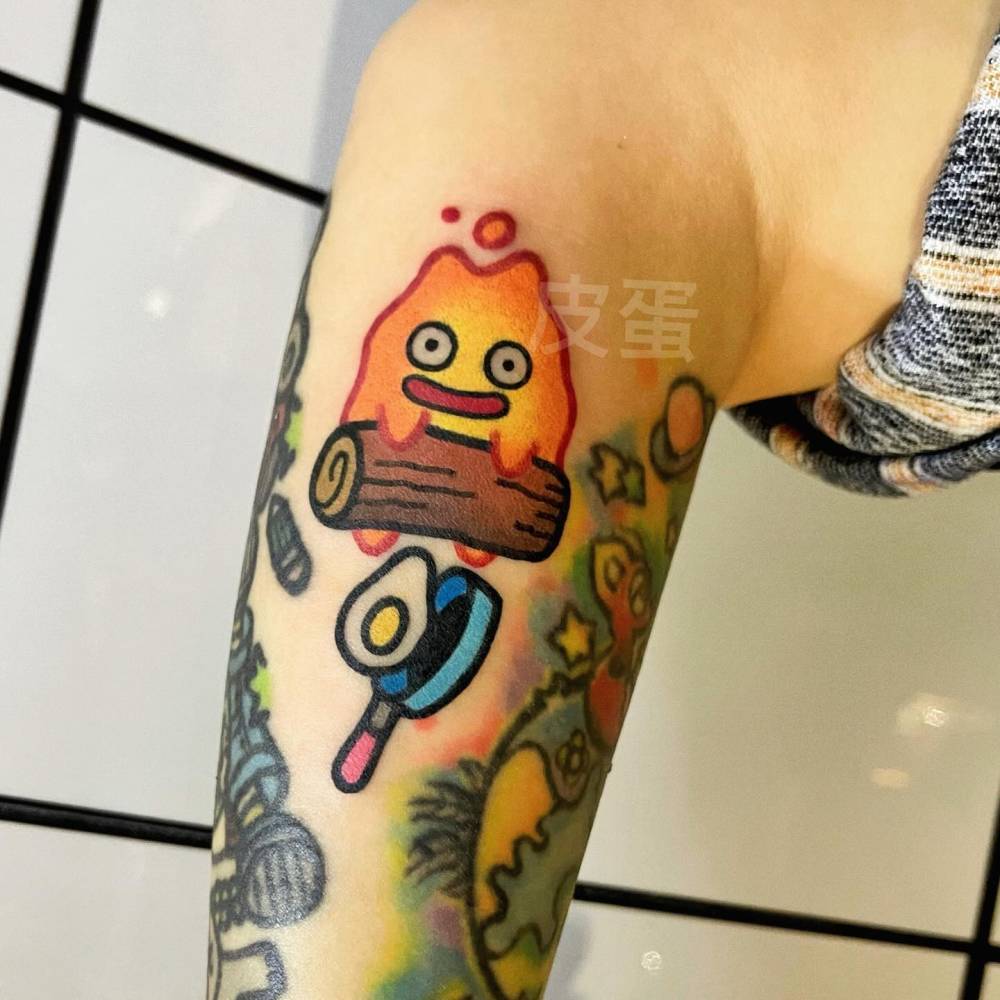 Calcifer tattoo in cartoon style located on the inner forearm.