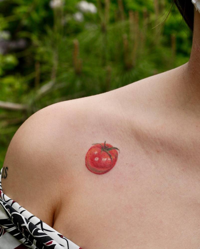 Watercolor style tomato tattoo located on the collarbone.