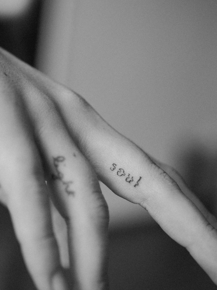 Blurry effect word "soul" tattooed on the finger.