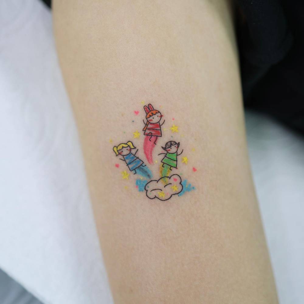 Powerpuff Girls tattoo in cartoon style done on the upper arm.