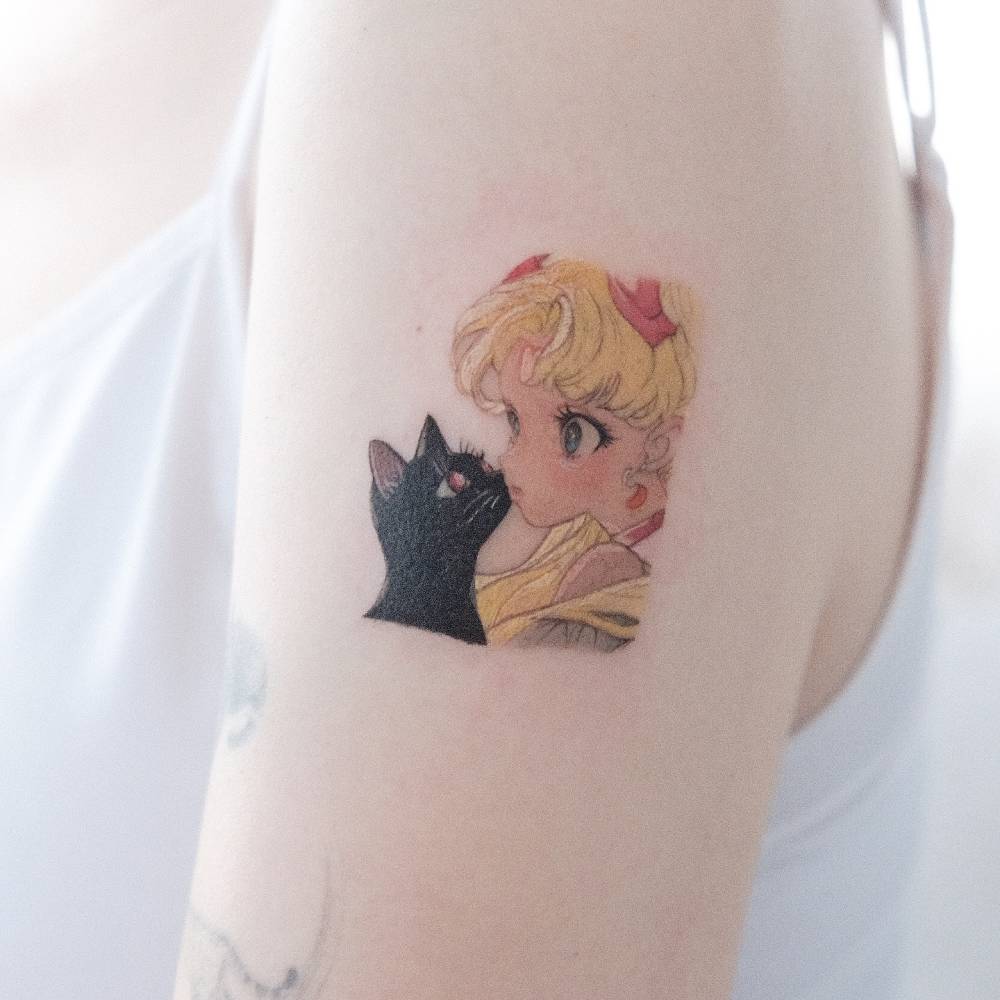 Sailor Moon tattoo located on the upper arm, cartoon style.
