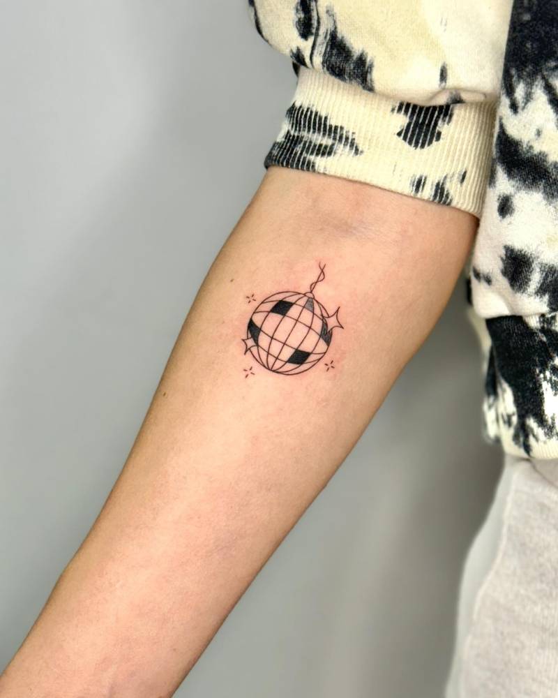 Illustrative style disco ball tattoo located on the inner forearm.