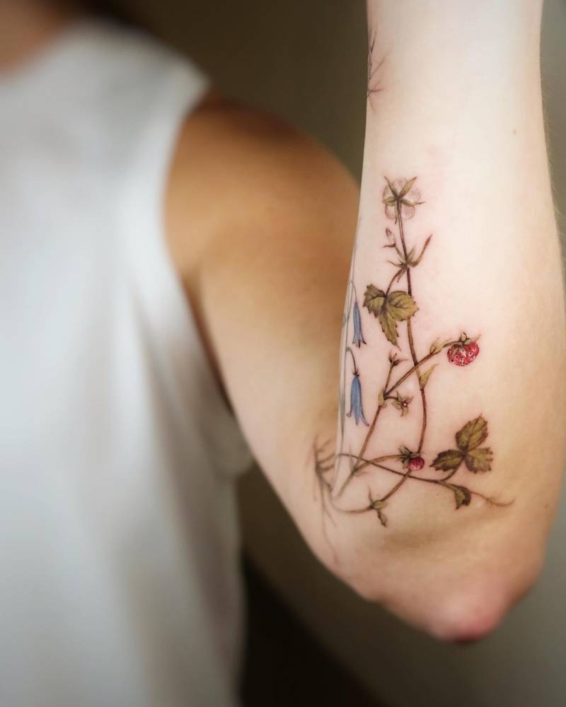 Wild strawberries tattoo located on the inner forearm.