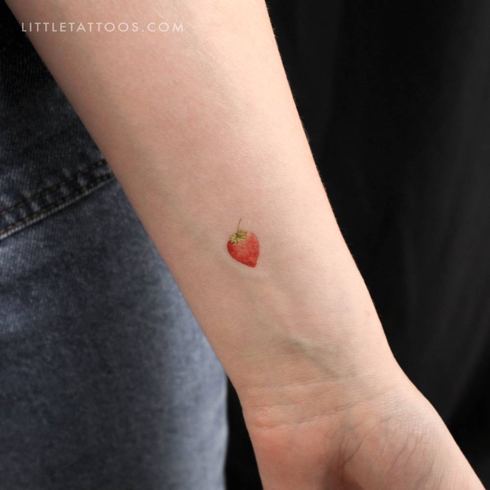 Watercolor strawberry temporary tattoo on the wrist.