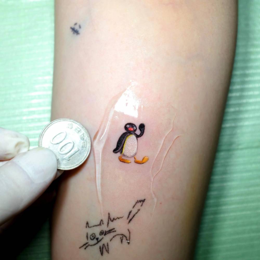 Pingu tattoo located on the inner forearm.