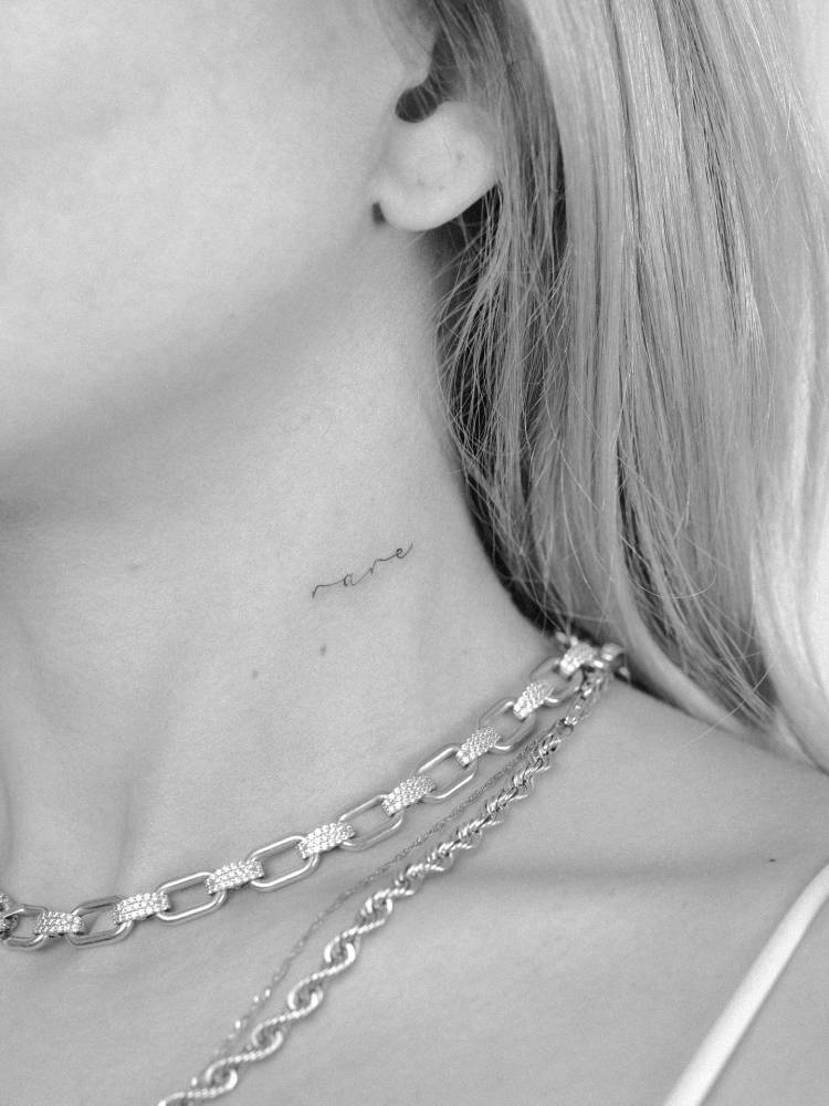 Word "rare" in script font tattooed on the neck.