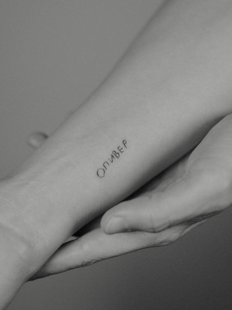 Russian word lettering tattoo located on the wrist.