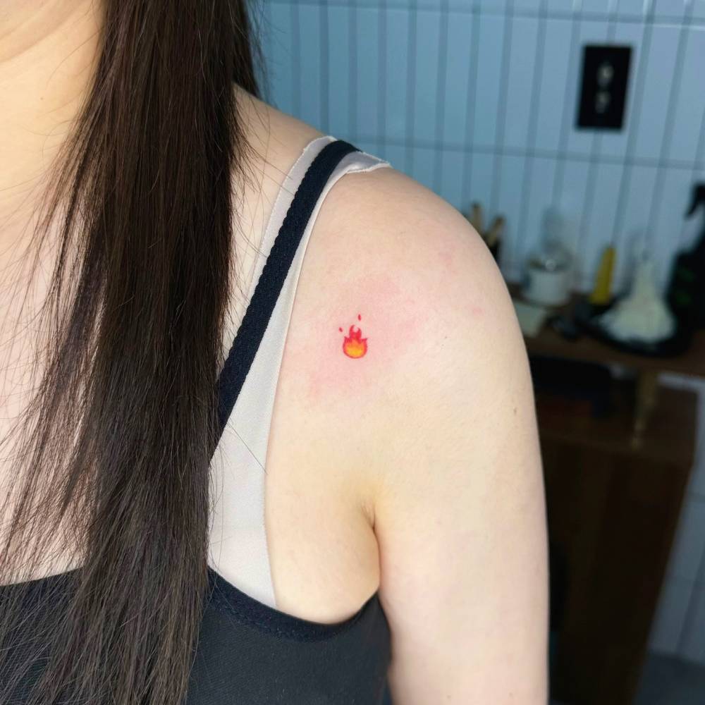 Fire tattoo hand poked on the shoulder.