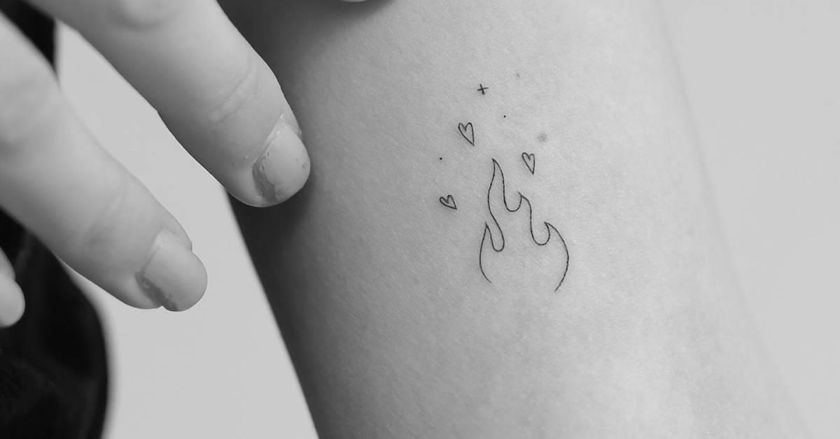 Fire and hearts tattoo located on the inner arm, done