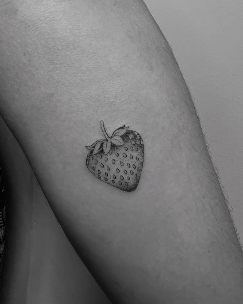Illustrative style strawberry tattoo located on the forearm.