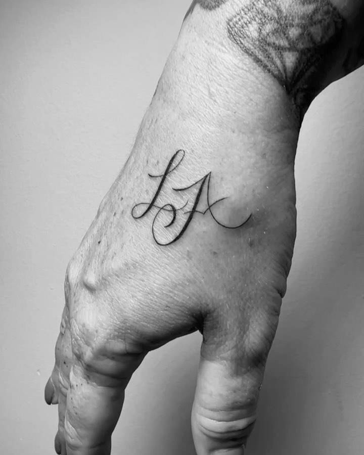 "LA" lettering tattoo located on the hand.