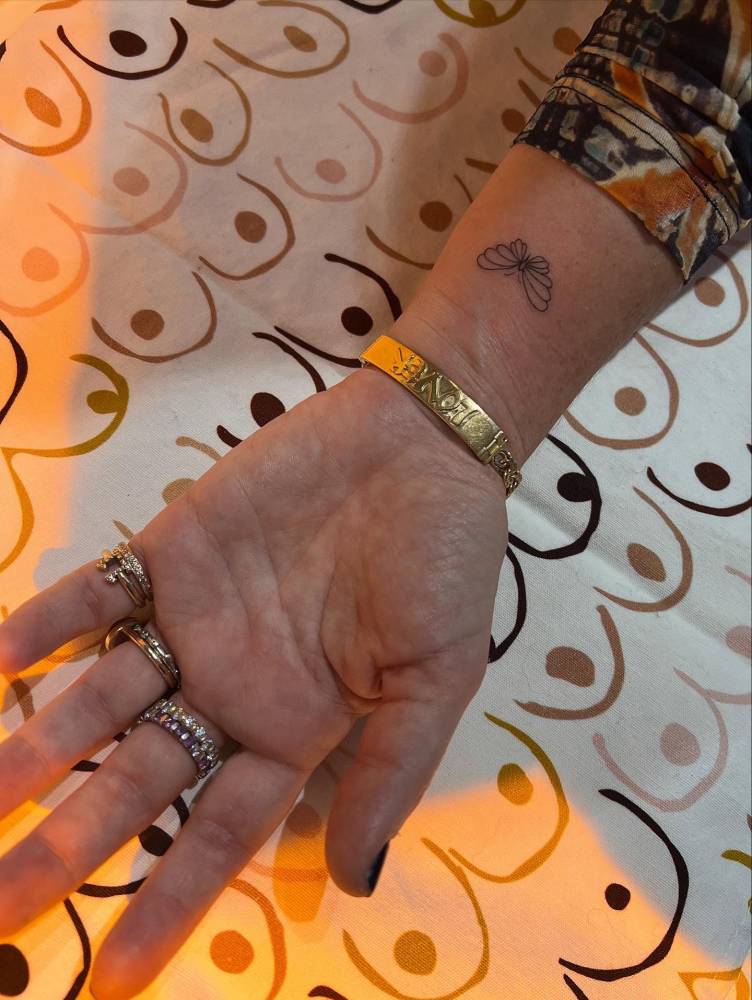 Butterfly tattoo in fine line style placed on the wrist.