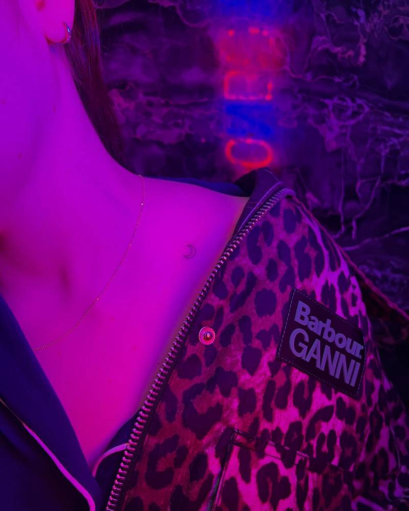 Tiny crescent moon tattoo placed on the collarbone.