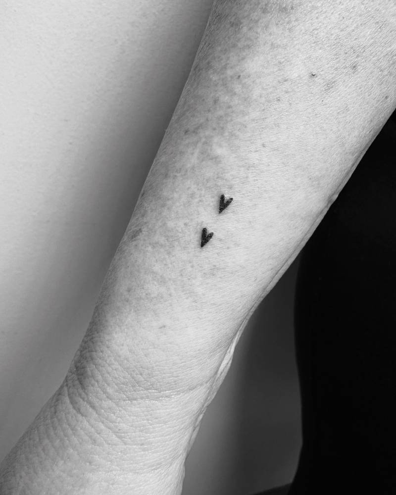 Two minimalistic hearts tattoo located on the wrist.