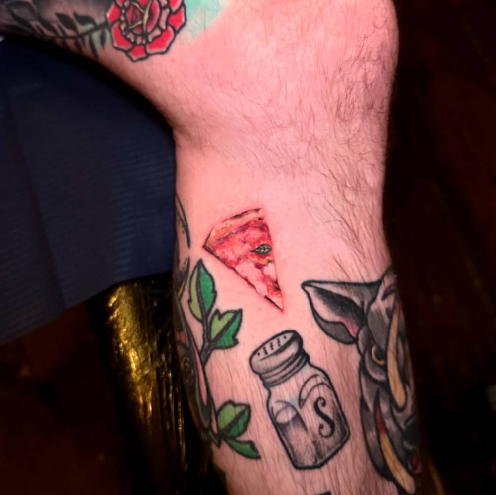 Micro-realistic style margherita pizza tattoo located on the calf.