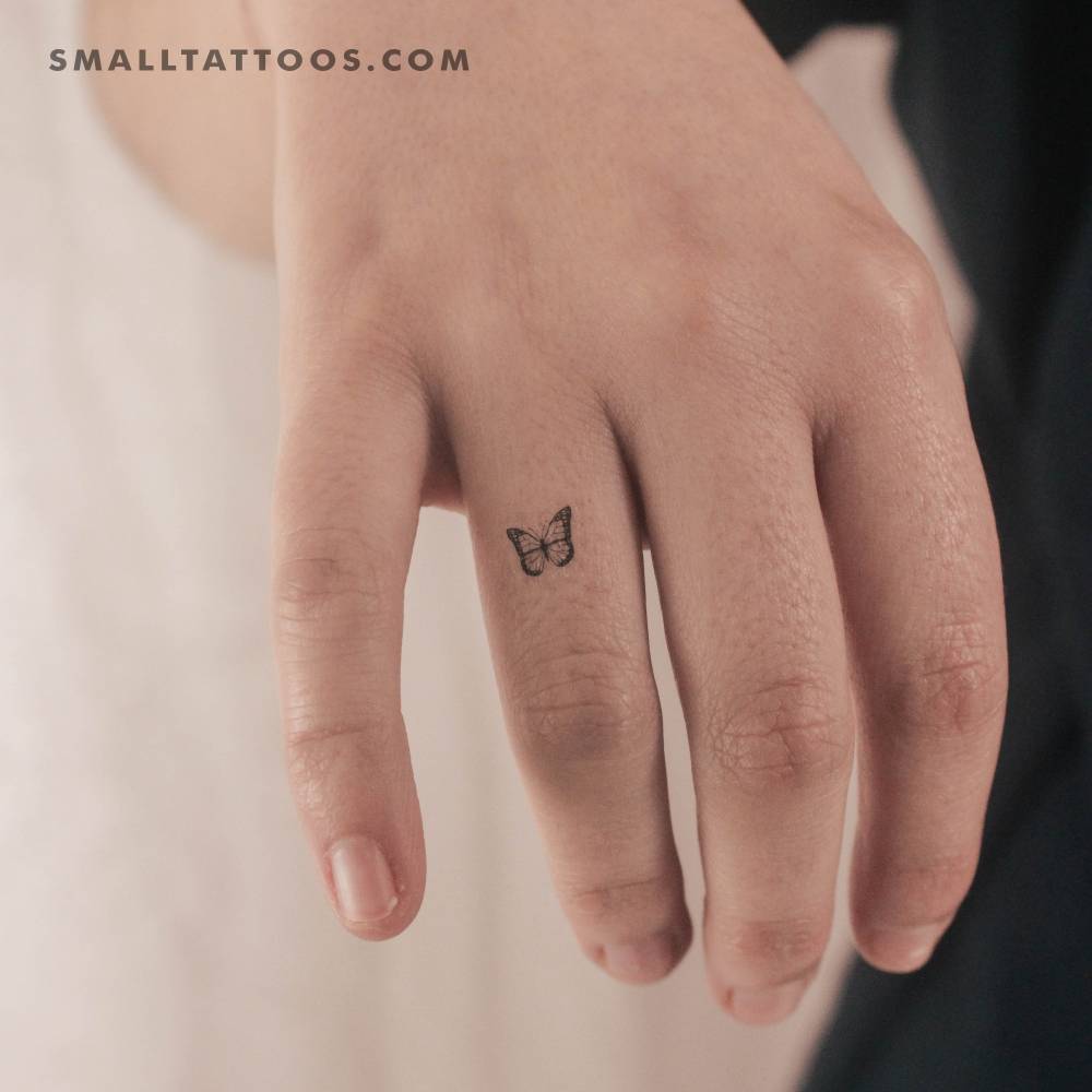 Tiny swallowtail butterfly temporary tattoo located on the finger.