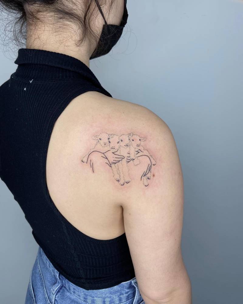 Hand poked lamb bundle tattooed on the shoulder blade.