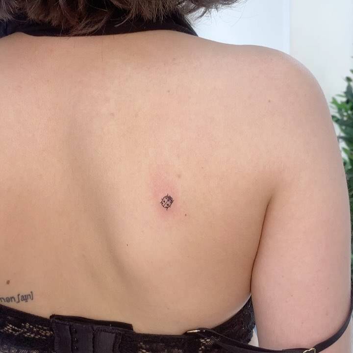 Minimalistic ladybug tattoo located on the shoulder blade.