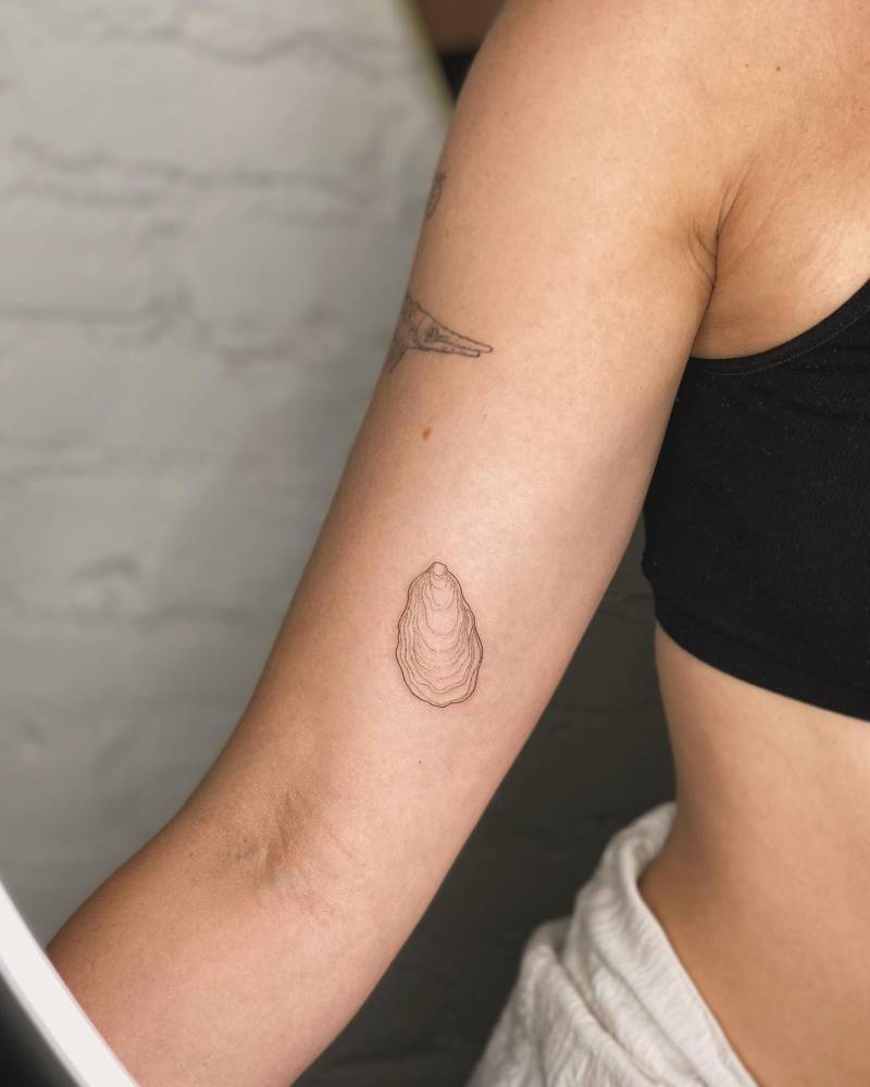 Fine line style oyster tattoo located on the inner arm.