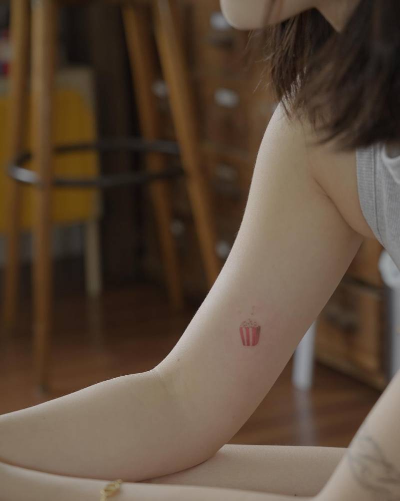 Popcorn tattoo in micro-realistic style located on the inner arm.
