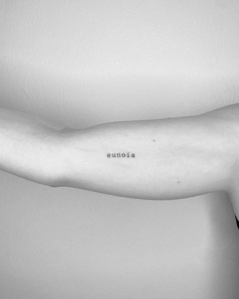 Tattoo of the word "eunoia" located on the inner arm.