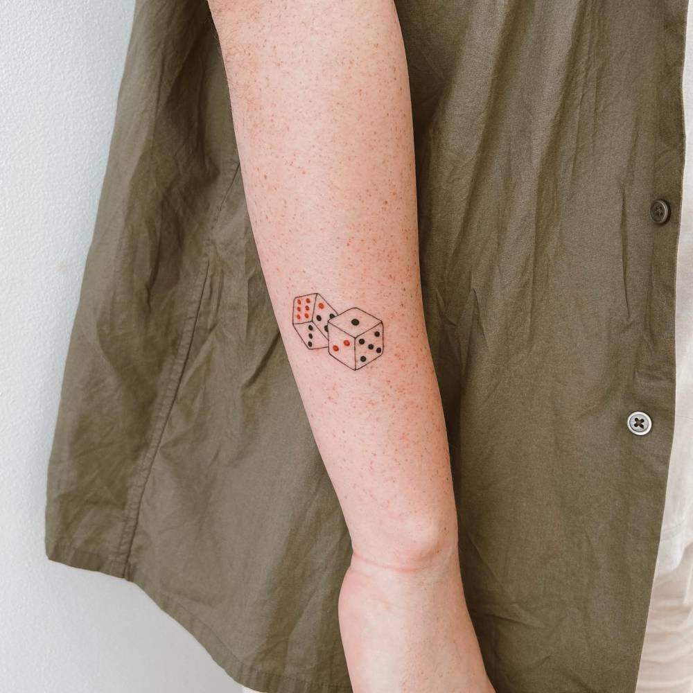 Hand poked dice tattoo located on the forearm.