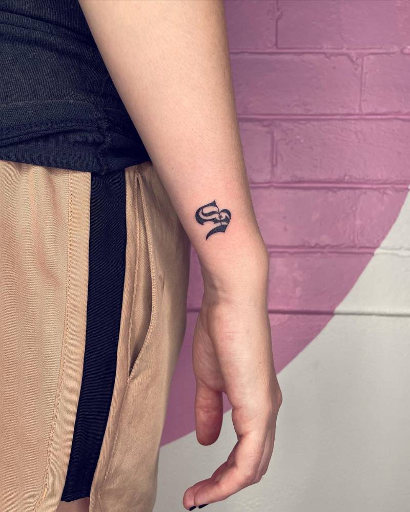 Hand poked gothic letter "S" tattoo located on the wrist.
