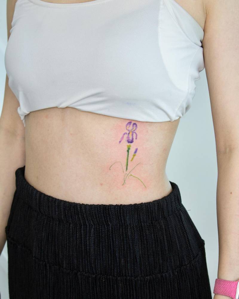Iris flower tattoo placed on the rib, watercolor style.