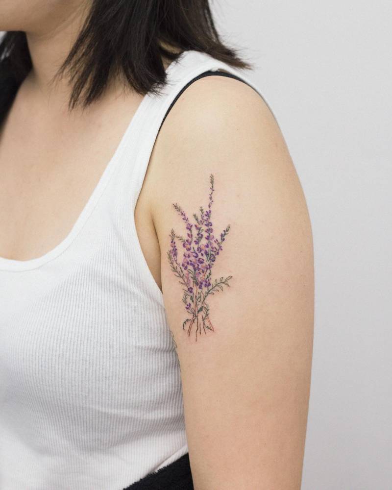 Watercolor style lavender bouquet tattoo placed on the upper arm.