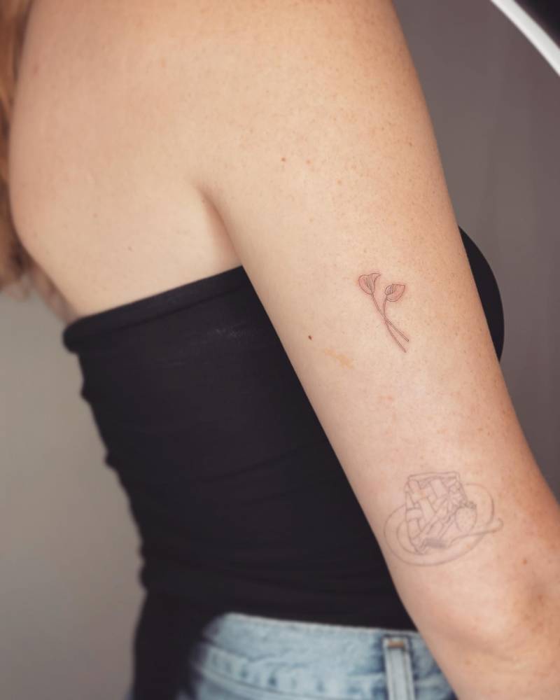 Fine line style anthurium tattoo done on the upper arm.