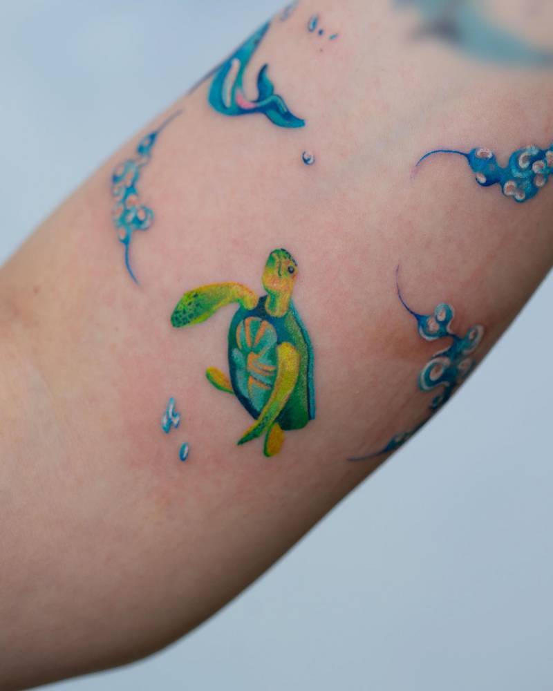 Turtle tattoo located on the inner forearm, watercolor style.
