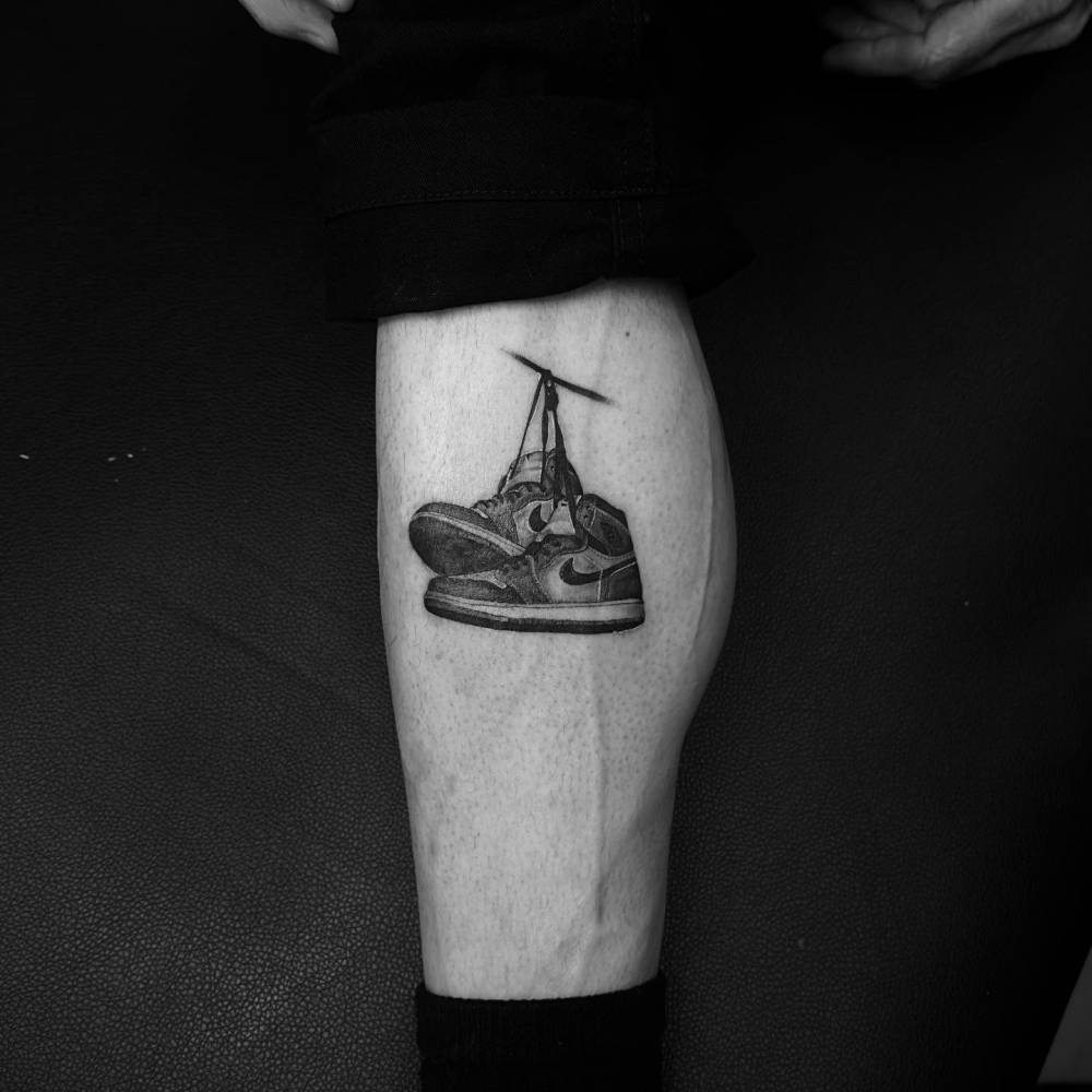 Air Jordan 1 tattoo done on the calf, micro-realistic style.