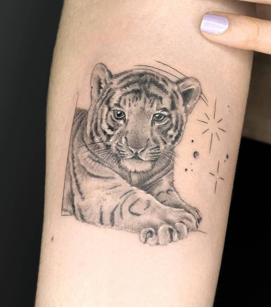 Tiger cub tattoo done on the inner forearm, micro-realistic style.
