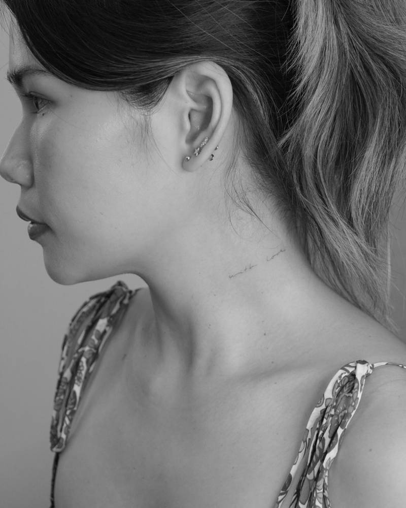 Tattoo that says "with love" handwritten on the neck.