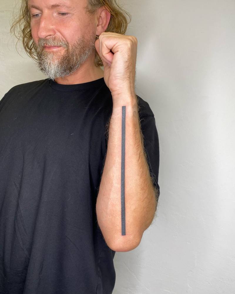 Line tattooed on the forearm, geometric style.