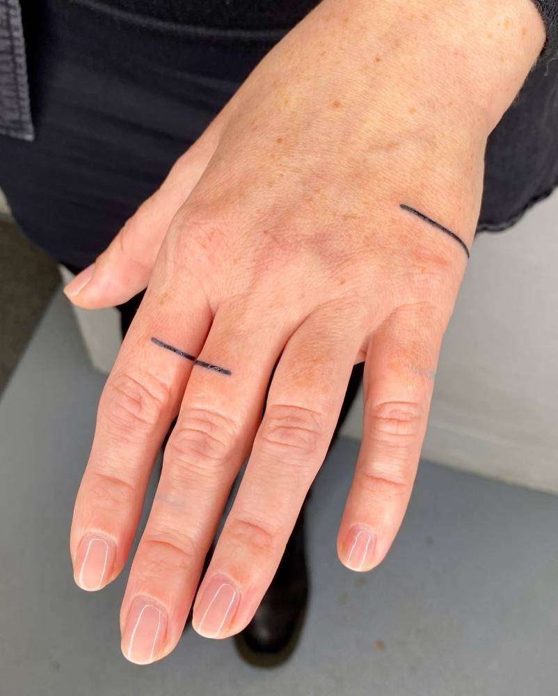 Tiny minimalistic lines tattooed on the hand.