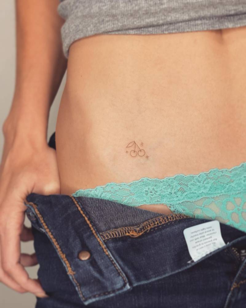 Tiny minimalistic cherry tattoo located on the pelvis.