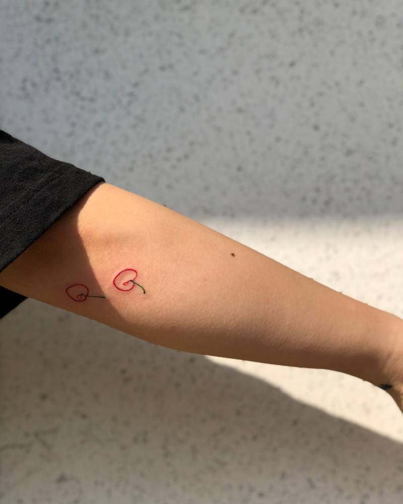 Minimalistic cherries tattoo located on the elbow.