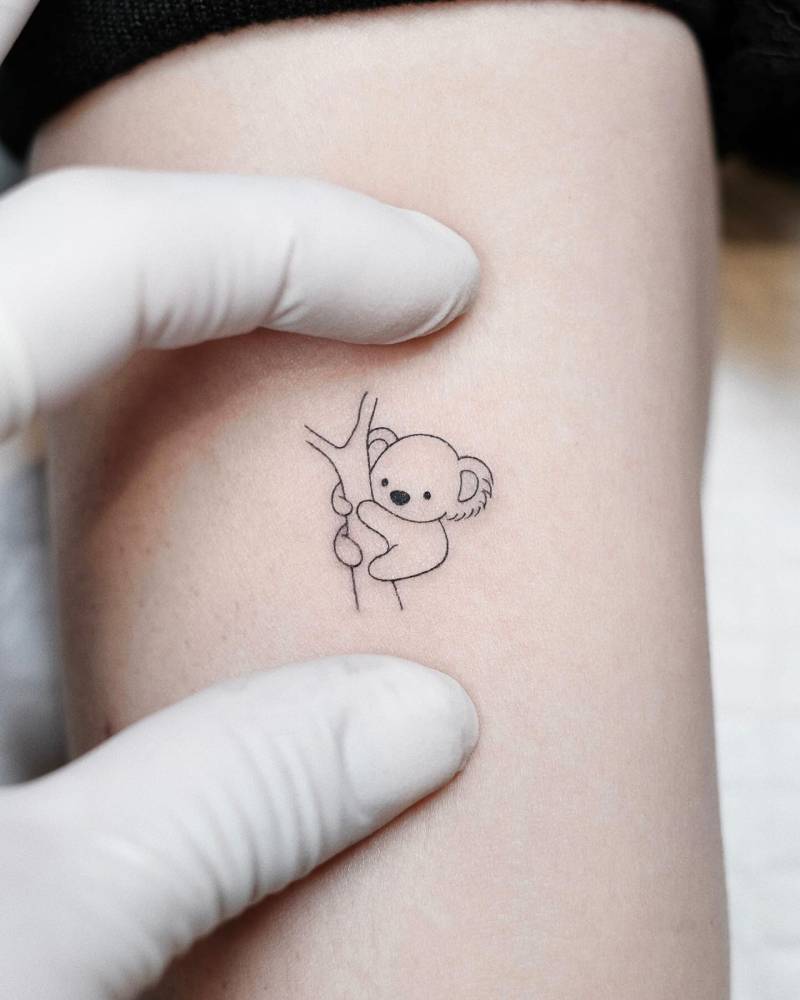 Minimalistic koala tattooed on the inner arm, fine line style.