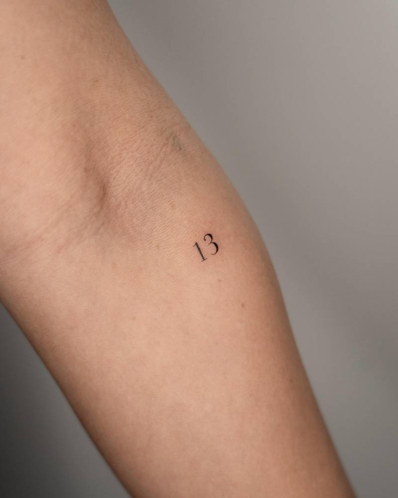 Lucky "13" tattoo located on the inner forearm.