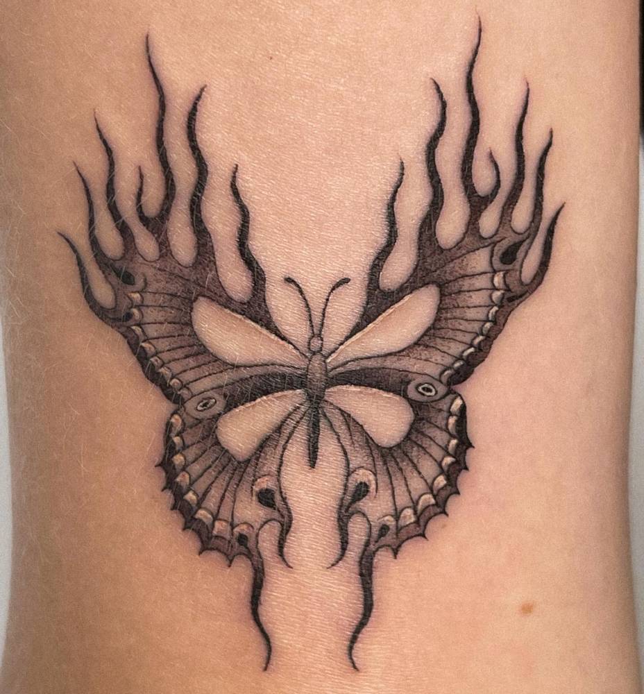 Illustrative style butterfly tattoo located on the tricep.