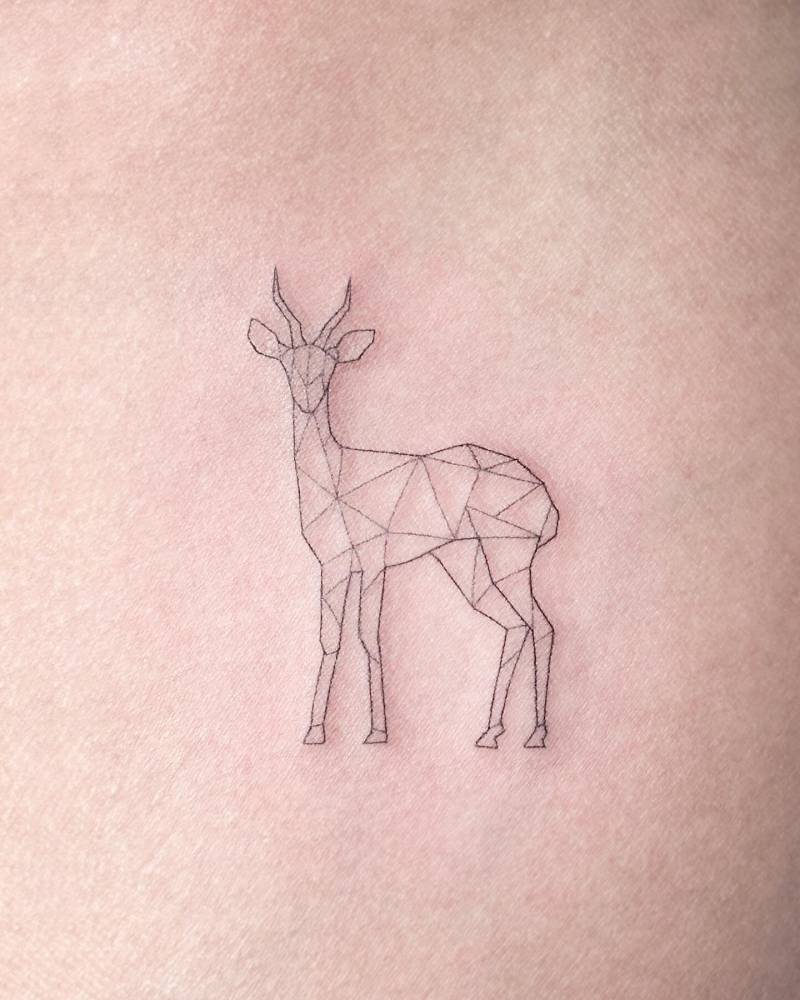 Geometric deer tattoo located on the inner arm, fine line style.