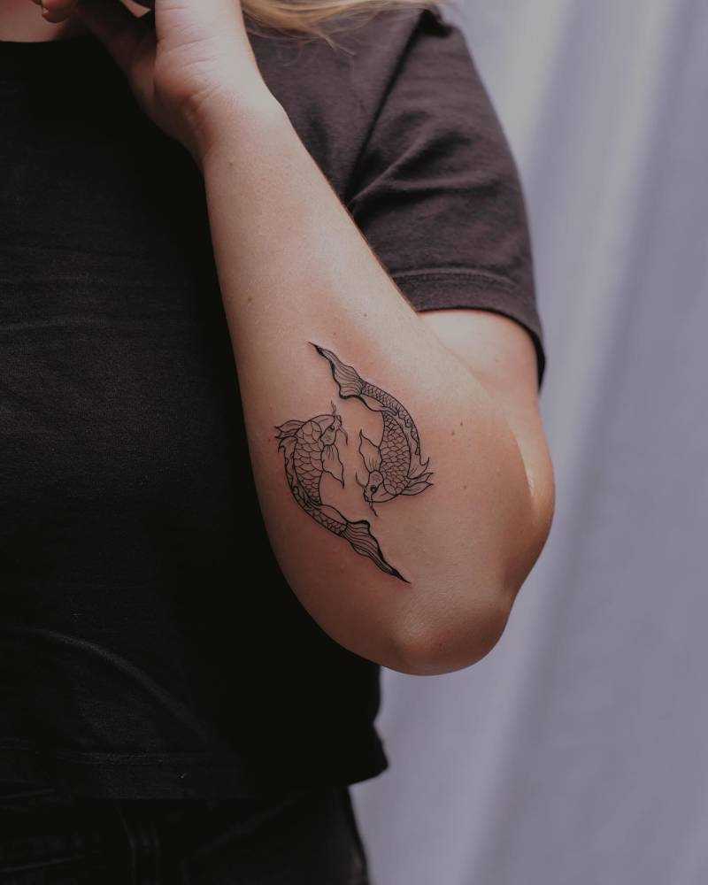 Two opposite fish tattoo placed on the forearm.