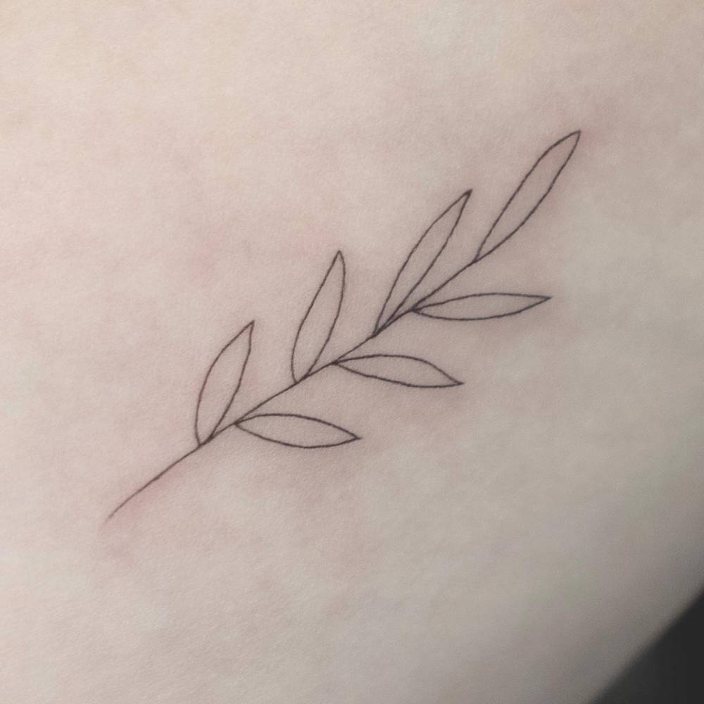 Minimalistic style leaves tattoo done on the inner arm.