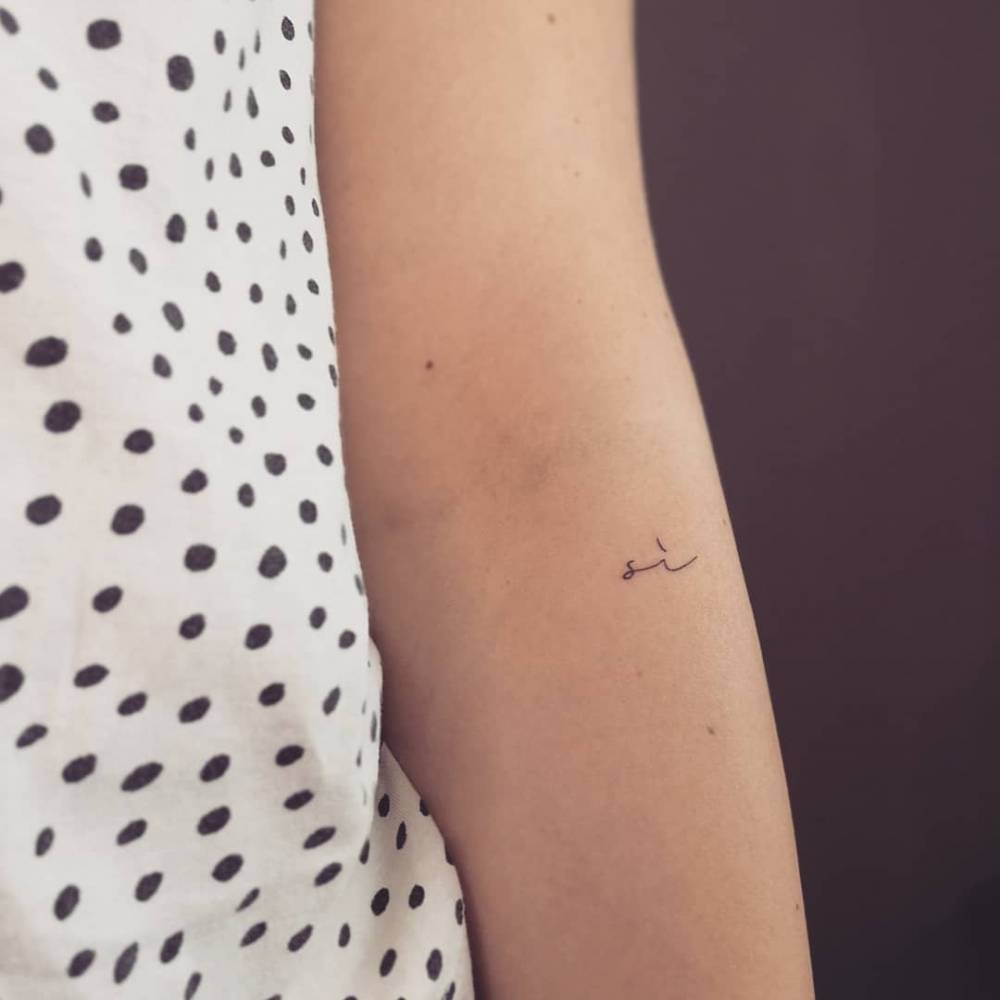 Word "sí" tattooed on the forearm.